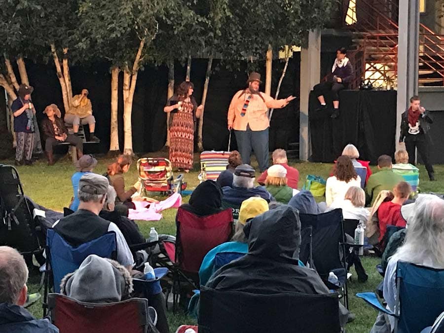 People sit in lawn chairs watching the performance