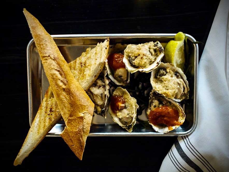 variety of oysters and bread on plate