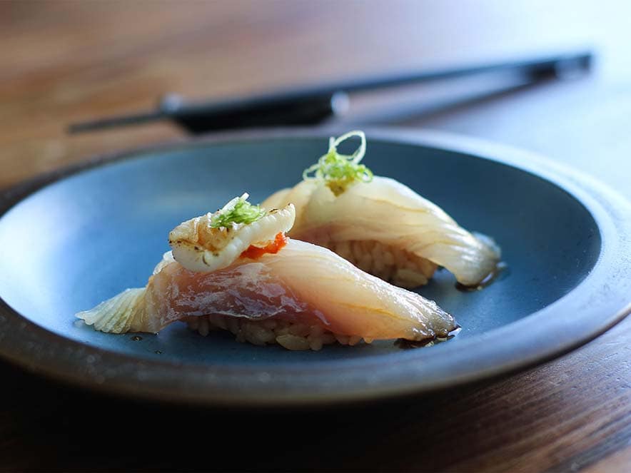 two pieces of sushi white fish on rice