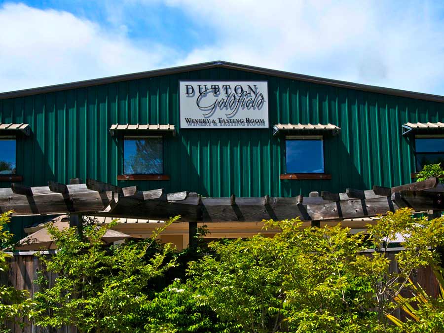 The exterior of the green winery has a sign with their name on it