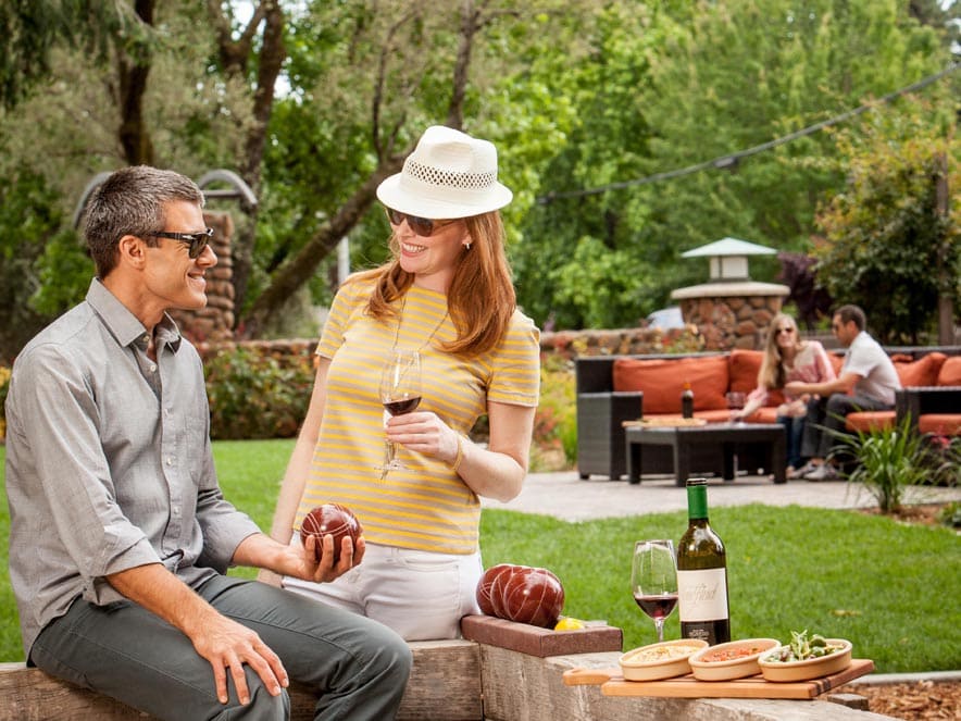 People enjoy wine in the garden outside of the winery