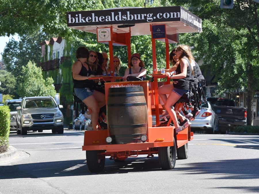 A groups rides the party bike in downtown Healdsburg with Bike Healdsburg