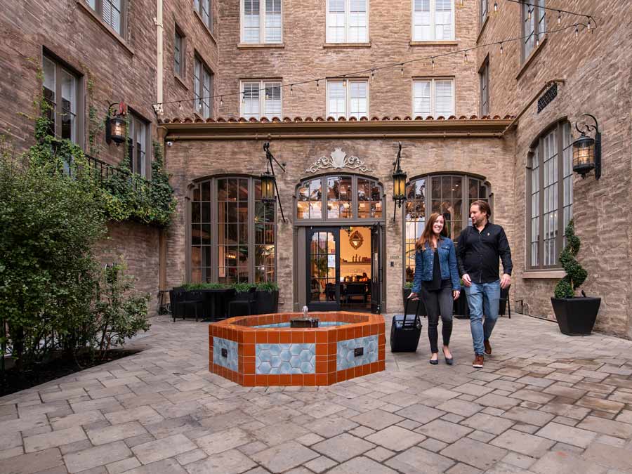 People smile and walk in the historic, stone courtyard