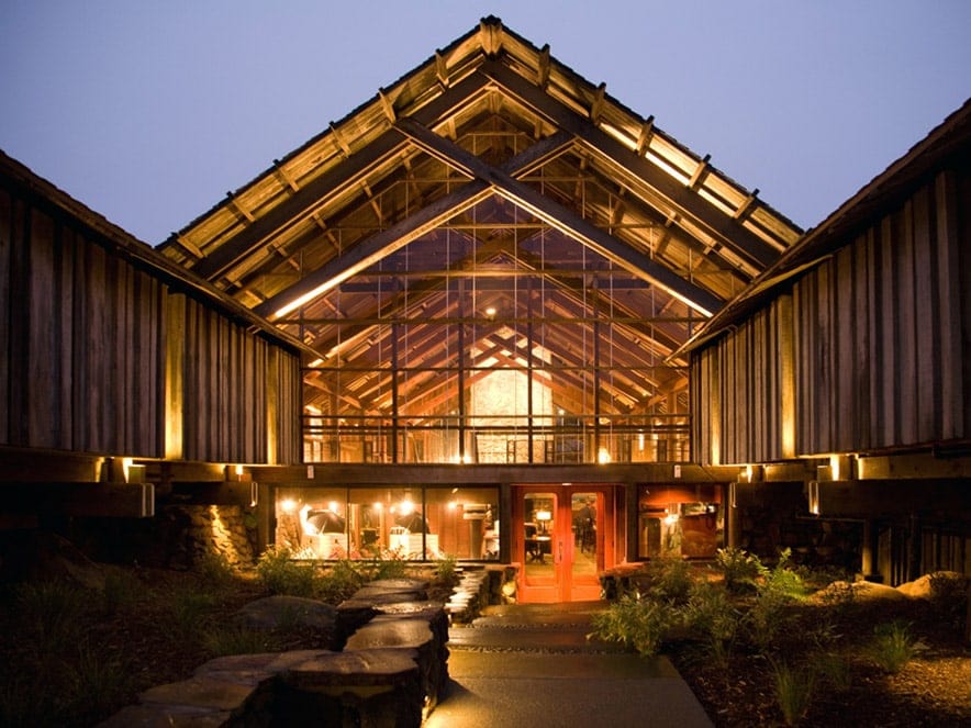 Lights blaze inside of a wooden facade for Timber Cove Resort, Jenner