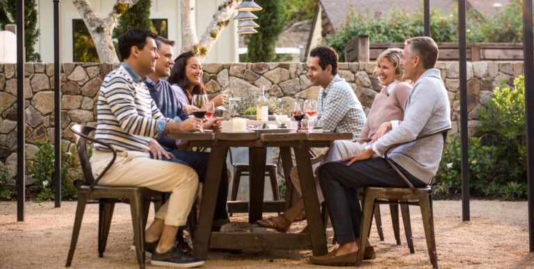 Friends dining outside in front a rock wall