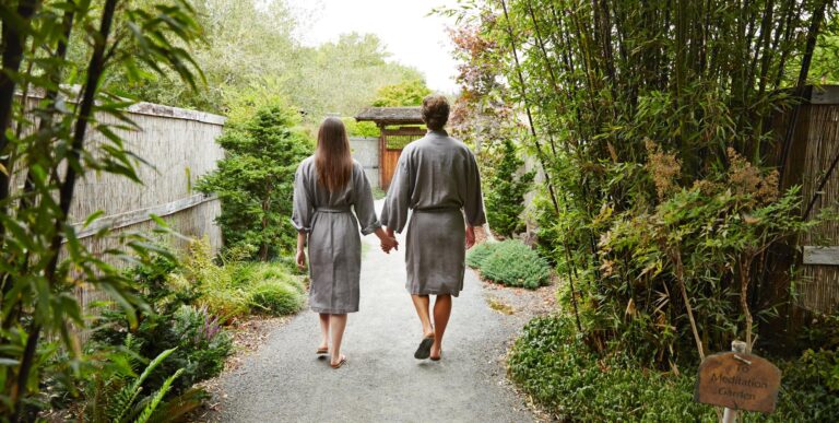 Couple holding hands walking into Osmosis Meditation garden