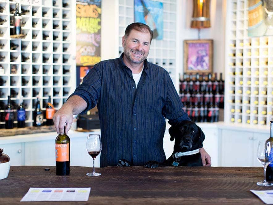 Brad Beard owner of Mercury Wines, Sonoma County with his dog in the tasting room 