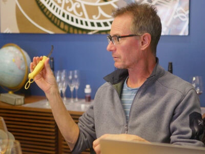 wine educator holding up a tool that is use to slide the grape skins