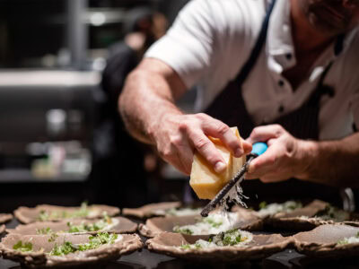 chef grating cheese on top of dinner plate at cyrus restaurant in geyserville