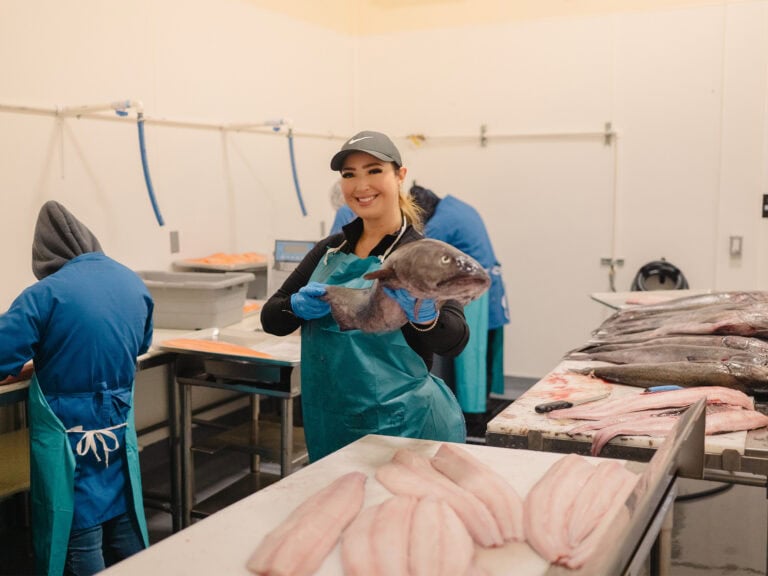 ana with ana's seafood market holding up a black cod fish