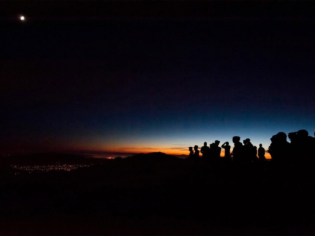 group of visitors stargazing and looking at the full moon during a night hike at sugarloaf state park in kenwood