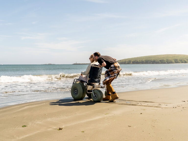 a couple at doran beach using their accessible wheelchair at the sonoma coast