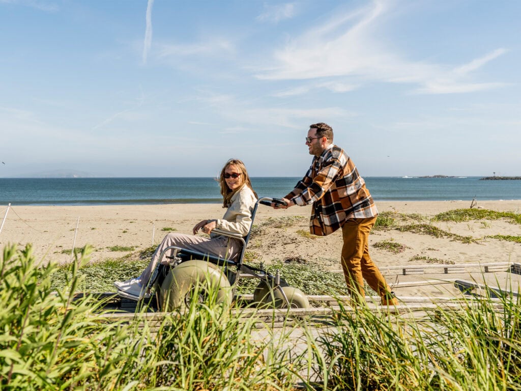 couple using the beach wheelchair at doran beach in sonoma county