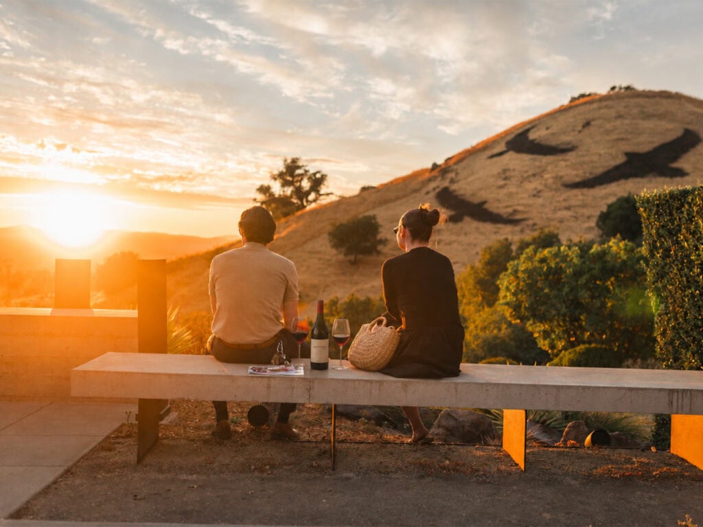 a couple having a wine tasting during sunset