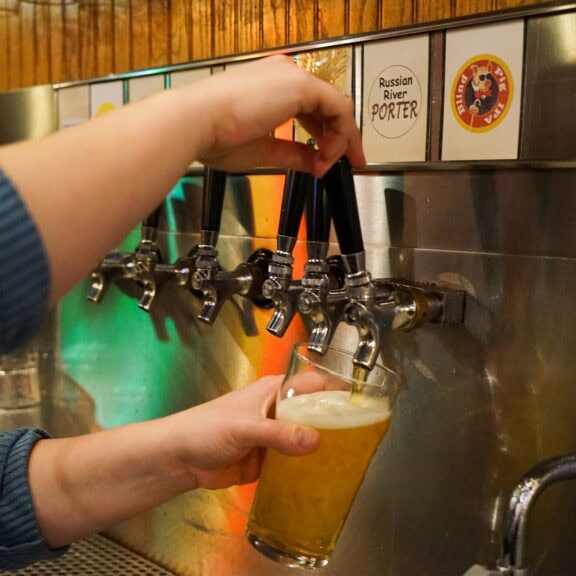 pouring beer at out a tap at russian river brewery