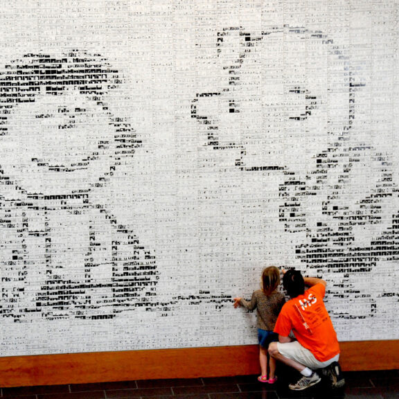 people looking through the iconic images of the peanuts comics at the museum